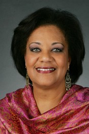 A headshot of Prof Tiffany Ruby Patterson, a middle aged black woman gracefully made up and wrapped in a pink shawl