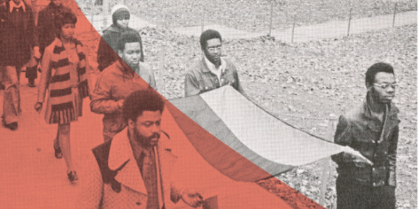 old photo of four men walking carrying a flag