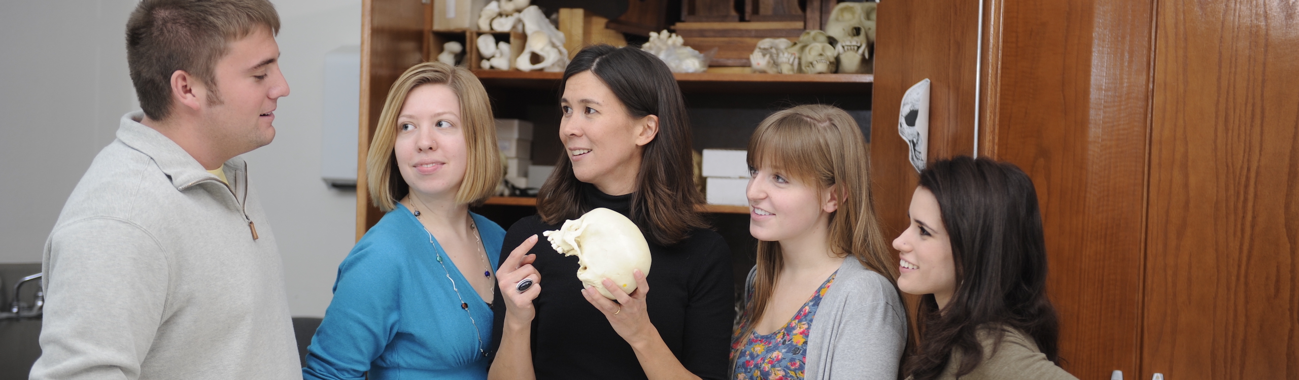 professor showing a skull to a group of students