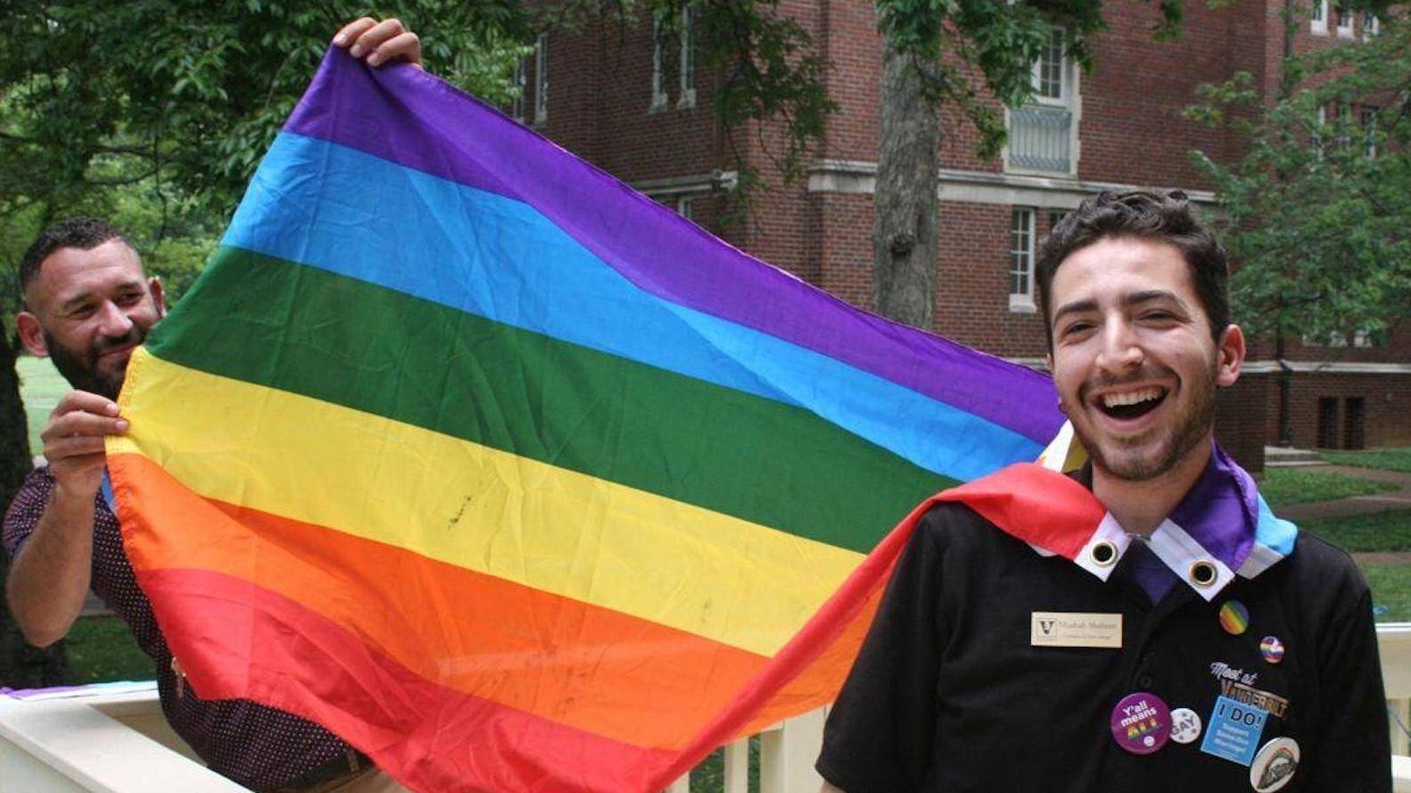 Musbah Shaheen with man holding up rainbow Pride flag