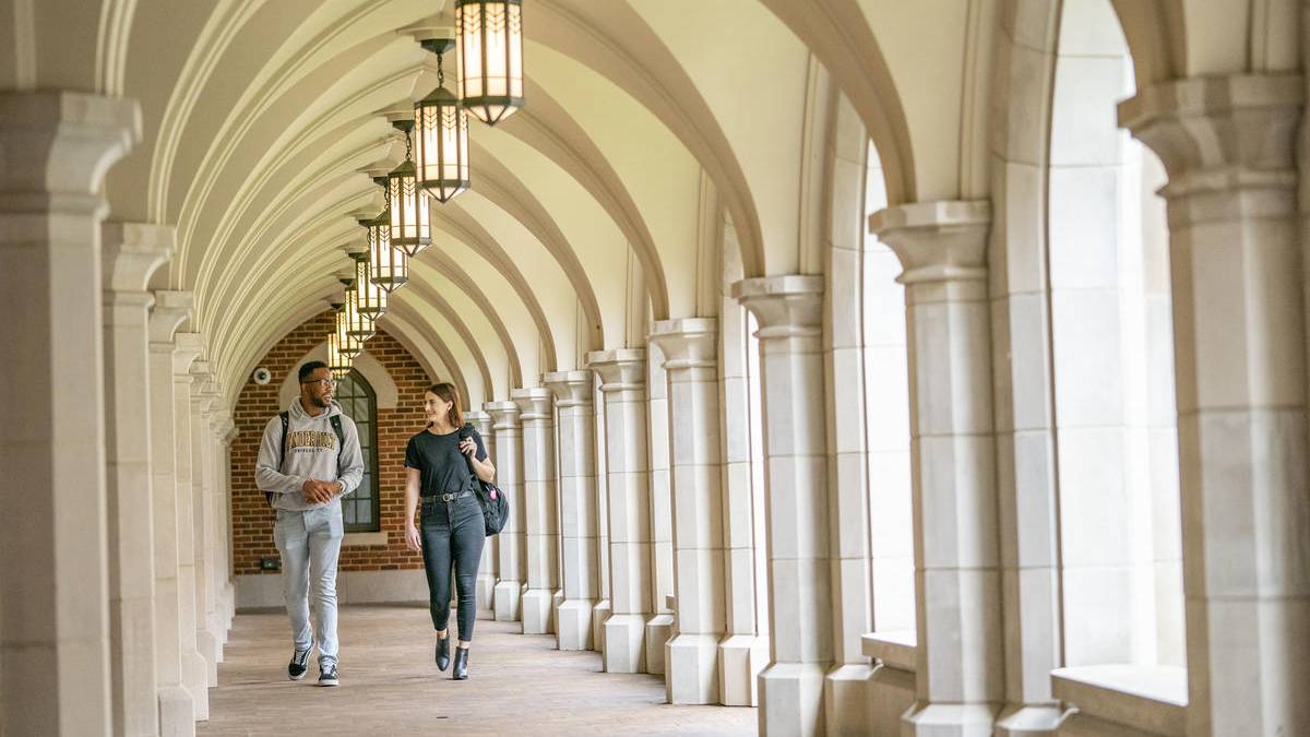 two students walk through the open hallway of e. bronson ingram residential college