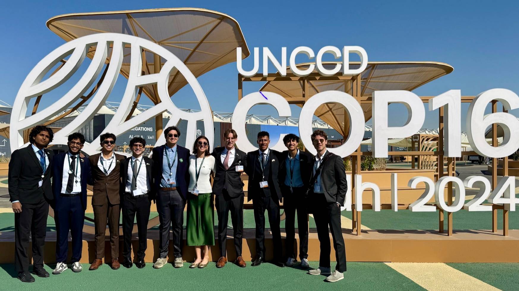 group of students outside conference sign