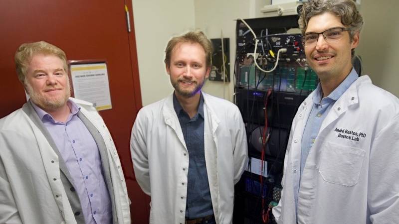 Jacob Westerberg with two faculty researchers, in lab cots