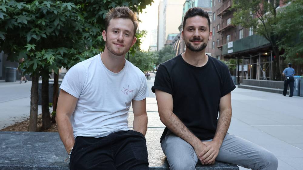 Schkolnick (left) and Aronskind (right) seated outside, smiling
